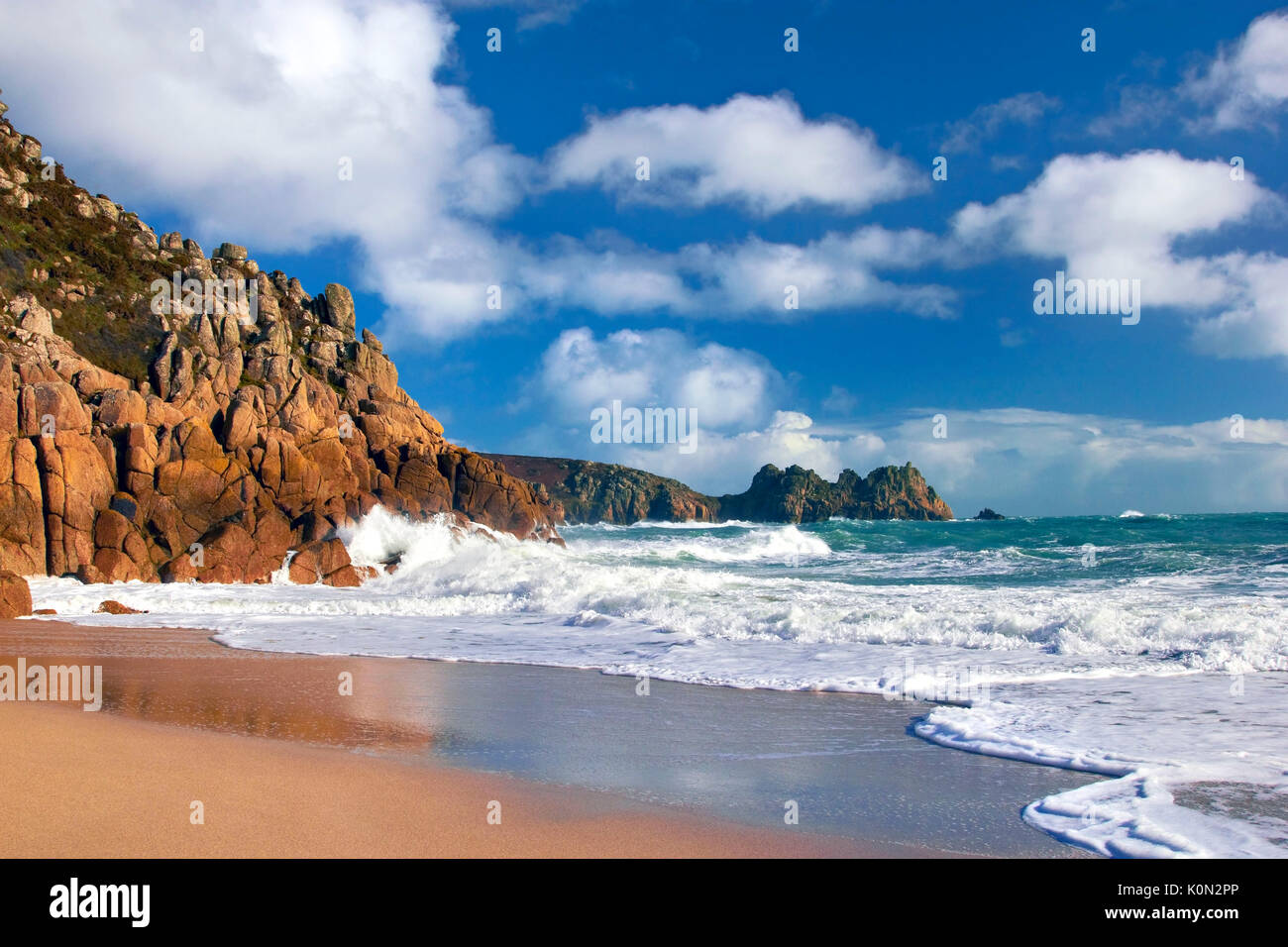 Une vue sur plage de porthcurno comme des vagues s'écraser sur les falaises Banque D'Images