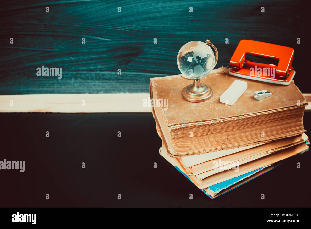 Vieux tableau noir avec des craies, des livres, un globe et un crayon. Une belle toile de fond pour l'éducation, un espace libre pour votre texte. retour à l'école. shallow dof. Banque D'Images Vieux tableau noir avec des craies, des livres, un globe et un crayon. Une belle toile de fond pour l'éducation, un espace libre pour votre texte. retour à l'école. shallow dof. Banque D'Images