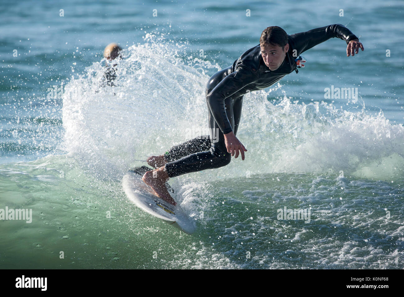Un surfer une vague à la plage de Fistral à Newquay. Banque D'Images
