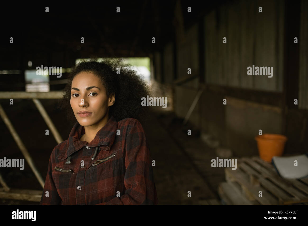 Portrait de femme belle farmer standing in barn Banque D'Images