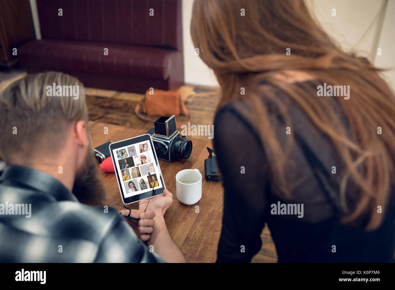 Portrait de collègues lookng sur tablette numérique à 24 en studio Banque D'Images