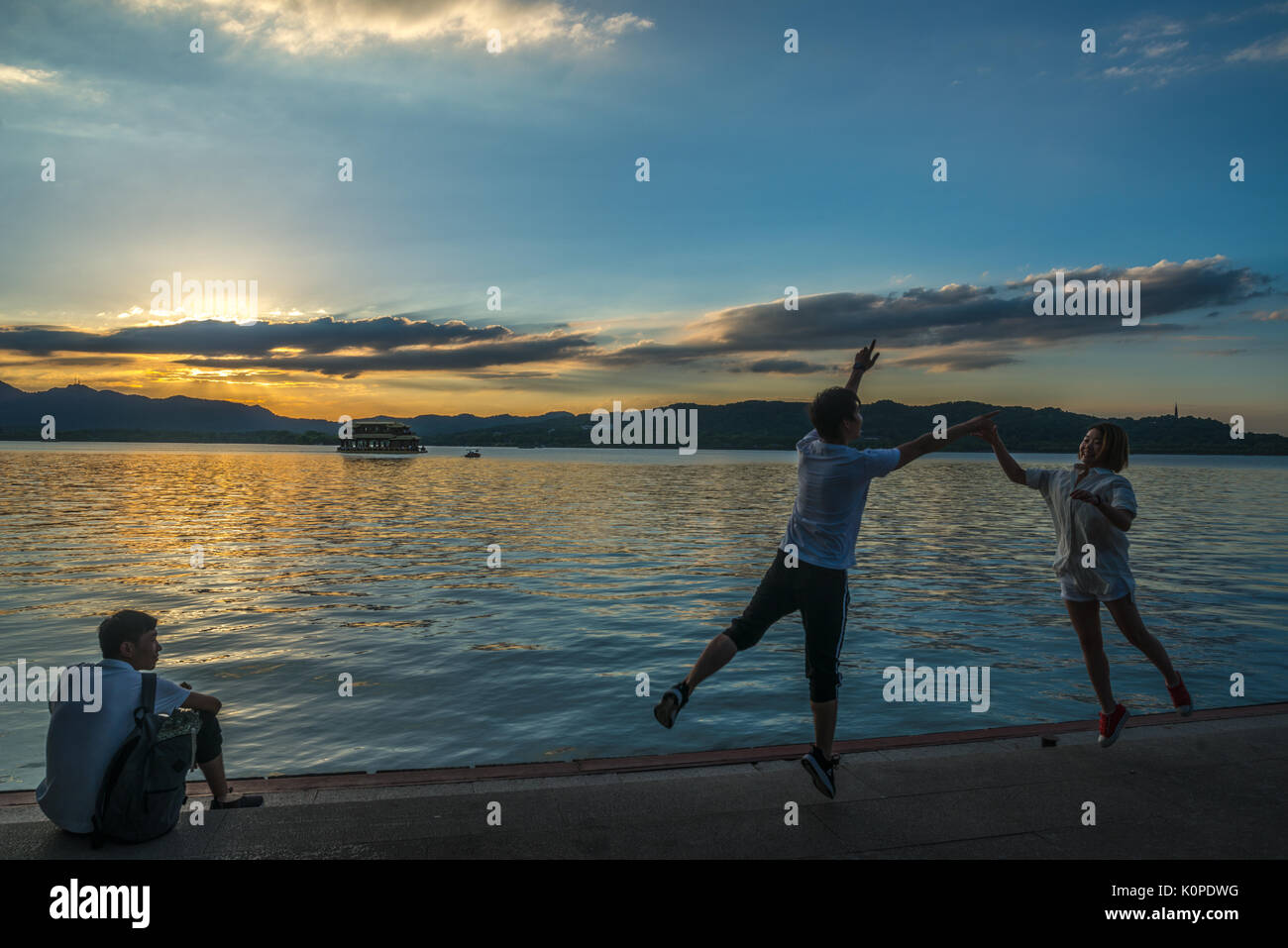 Des gens qui font des choses par le lac, le soir, heureux de franchise Banque D'Images