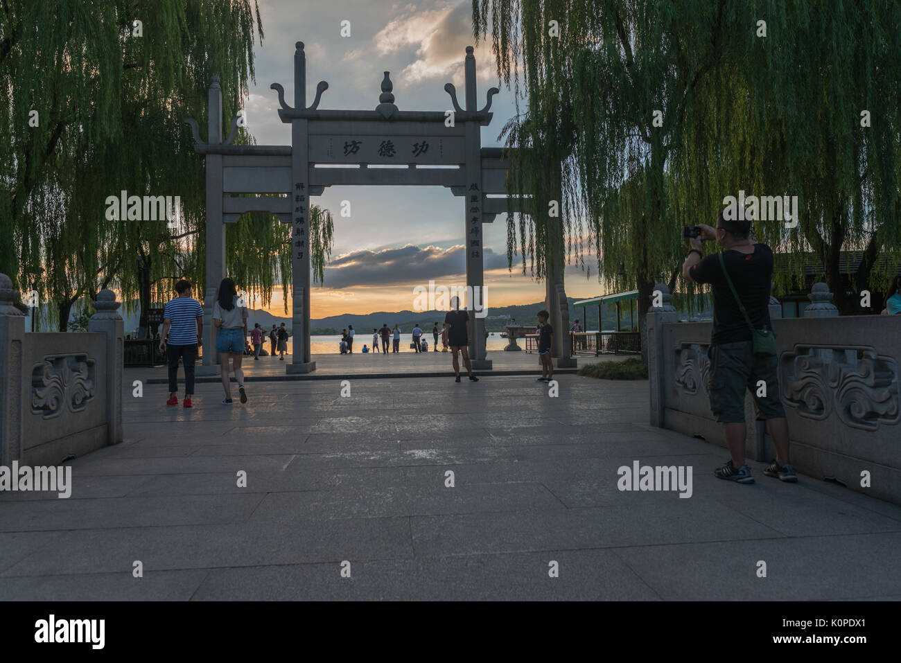 Des gens qui font des choses par le lac, le soir, heureux de franchise Banque D'Images