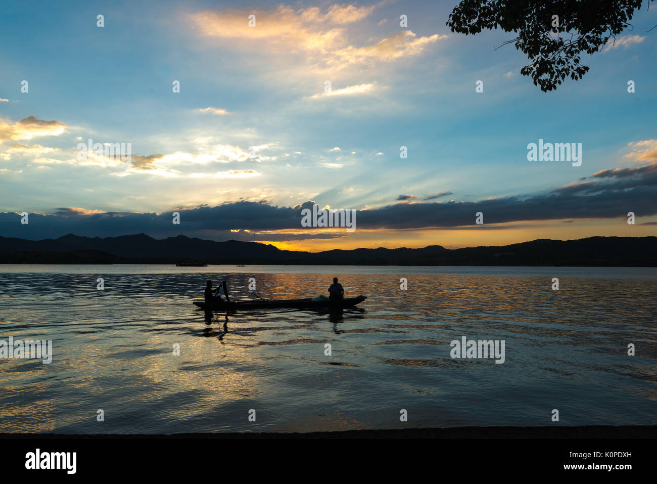 Des gens qui font des choses par le lac, le soir, heureux de franchise Banque D'Images