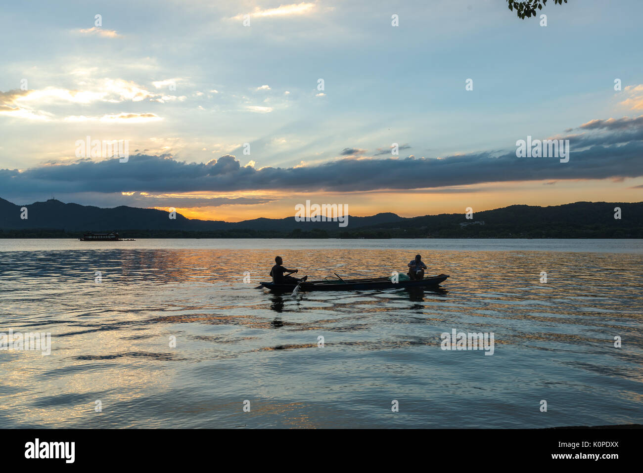 Des gens qui font des choses par le lac, le soir, heureux de franchise Banque D'Images