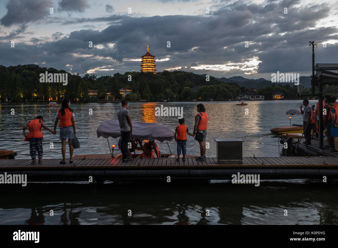 Des gens qui font des choses par le lac, le soir, heureux de franchise Banque D'Images