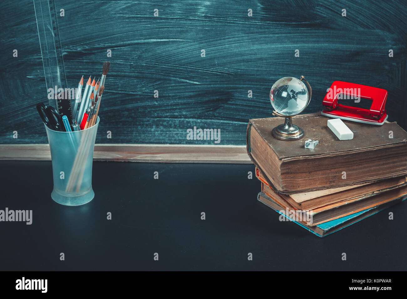 Vieux tableau noir avec des craies, des livres, un globe et un crayon. Une belle toile de fond pour l'éducation, un espace libre pour votre texte. retour à l'école. shallow dof. Banque D'Images Vieux tableau noir avec des craies, des livres, un globe et un crayon. Une belle toile de fond pour l'éducation, un espace libre pour votre texte. retour à l'école. shallow dof. Banque D'Images
