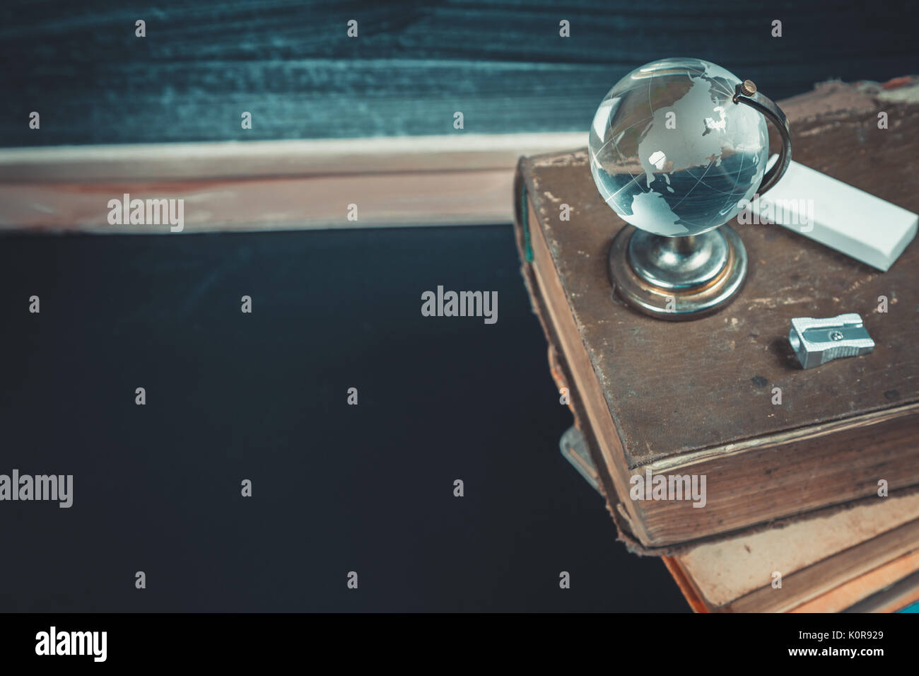 Vieux tableau noir avec des craies, des livres, un globe et un crayon. Une belle toile de fond pour l'éducation, un espace libre pour votre texte. retour à l'école. shallow dof. Banque D'Images Vieux tableau noir avec des craies, des livres, un globe et un crayon. Une belle toile de fond pour l'éducation, un espace libre pour votre texte. retour à l'école. shallow dof. Banque D'Images