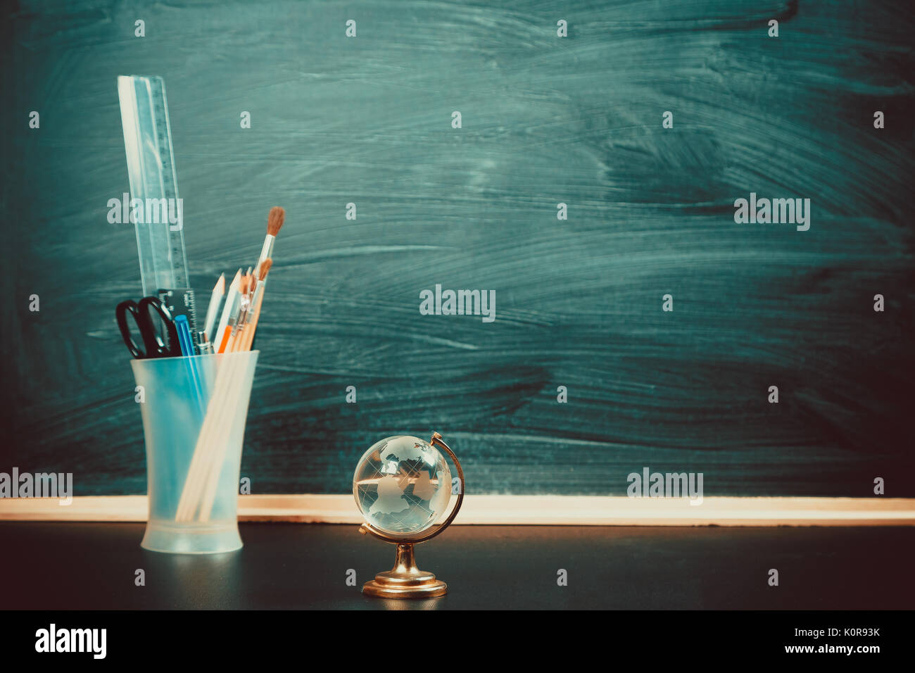 Vieux tableau noir avec des craies, des livres, un globe et un crayon. Une belle toile de fond pour l'éducation, un espace libre pour votre texte. retour à l'école. shallow dof. Banque D'Images Vieux tableau noir avec des craies, des livres, un globe et un crayon. Une belle toile de fond pour l'éducation, un espace libre pour votre texte. retour à l'école. shallow dof. Banque D'Images