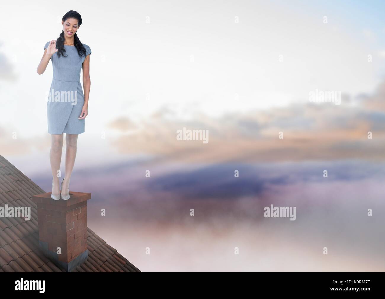 Digital composite of Businesswoman standing on Roof avec cheminée et ciel coloré Banque D'Images