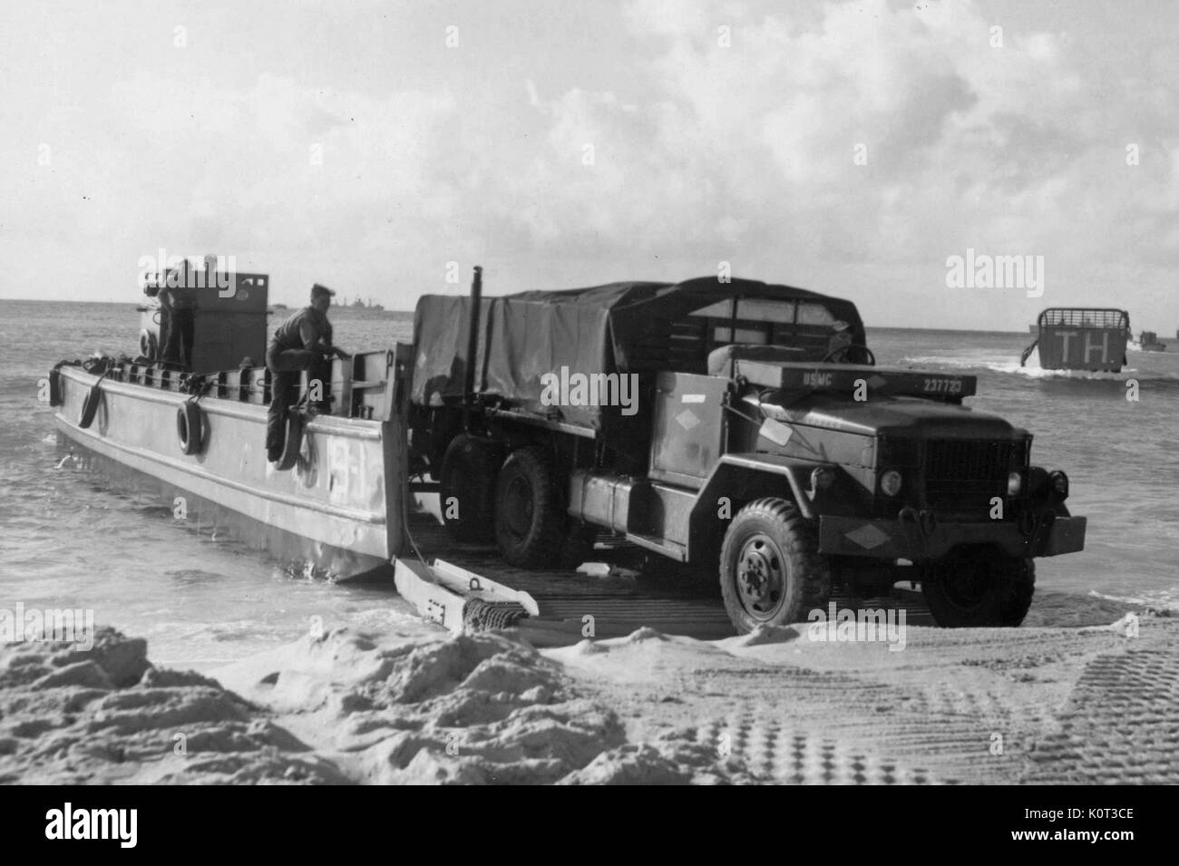 Marines américains arrivant au Vietnam pendant la guerre du Vietnam, débarquant d'un camion militaire d'un débarquement sur une plage, d'autres engins de débarquement visible à l'arrière-plan, 1965. Banque D'Images