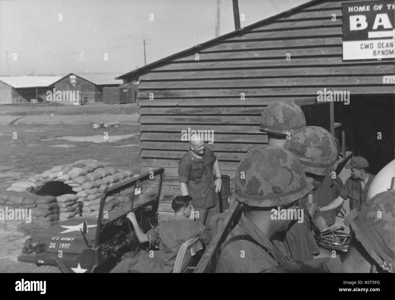 Une photographie des membres de la United States Army Première Division d'infanterie dans la circonscription de la bande d'appoint de camions transportant leurs instruments, d'autres militaires sont en conversation avec les autres sur le terrain, au Vietnam, en 1967. Banque D'Images