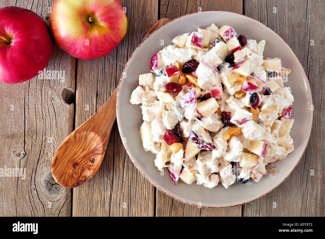 Salade d'automne avec le poulet, les pommes, les noix et les canneberges, ci-dessus sur fond de bois rustique Banque D'Images