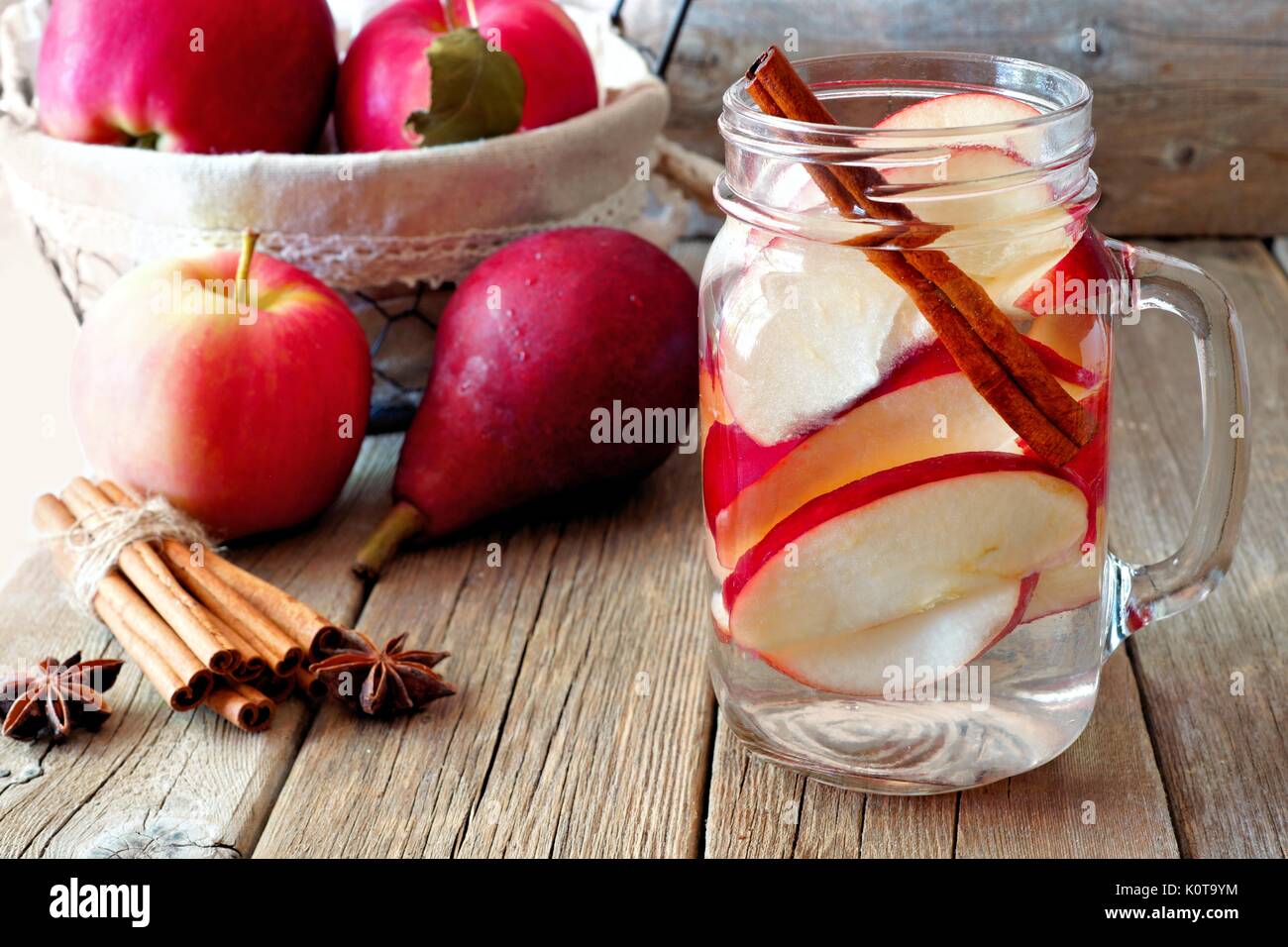 Le thème de l'automne l'eau detox avec Apple, la cannelle et d'une poire rouge pot Mason. Scène sur fond de bois rustique Banque D'Images