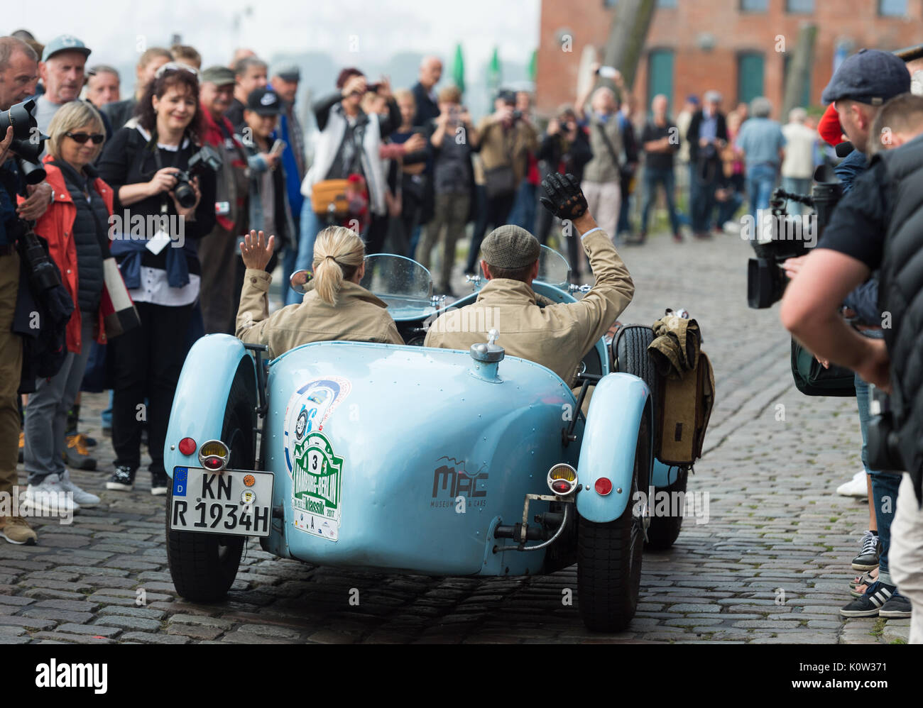 Hambourg, Allemagne. Août 24, 2017. Steffi (L) et Christoph Karle font des signes avec leurs mains d'une Riley spécial, construit en 1934, au début de l'Hamburg-Berlin rallye de voitures anciennes à Hambourg, Allemagne, 24 août 2017. Environ 180 animaux ont commencé le rallye aujourd'hui. Photo : Christophe Gateau/dpa/Alamy Live News Banque D'Images