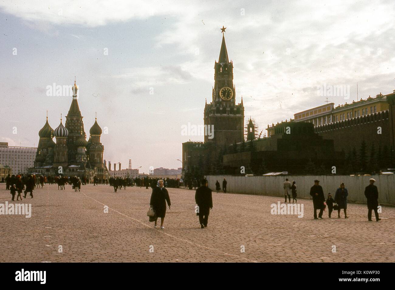 Vue panoramique au sud de la place Rouge, Moscou, Russie soviétique, URSS, novembre 1973. Les visiteurs sillonnent la place entre la cathédrale Saint-Basile à l'arrière-plan gauche et la tour de l'horloge Spasskaya à l'avant-plan droit à l'entrée du Kremlin. Le mur extérieur du Kremlin longe le bord droit en direction du tombeau de Lénine. Banque D'Images