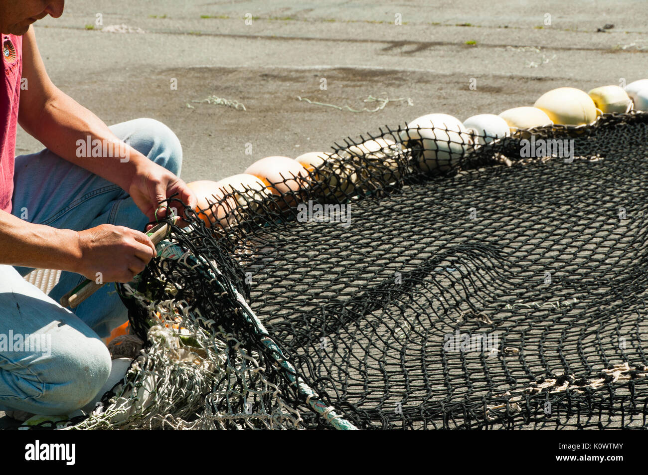 Fisherman Mending Fishing Net Banque D'Images