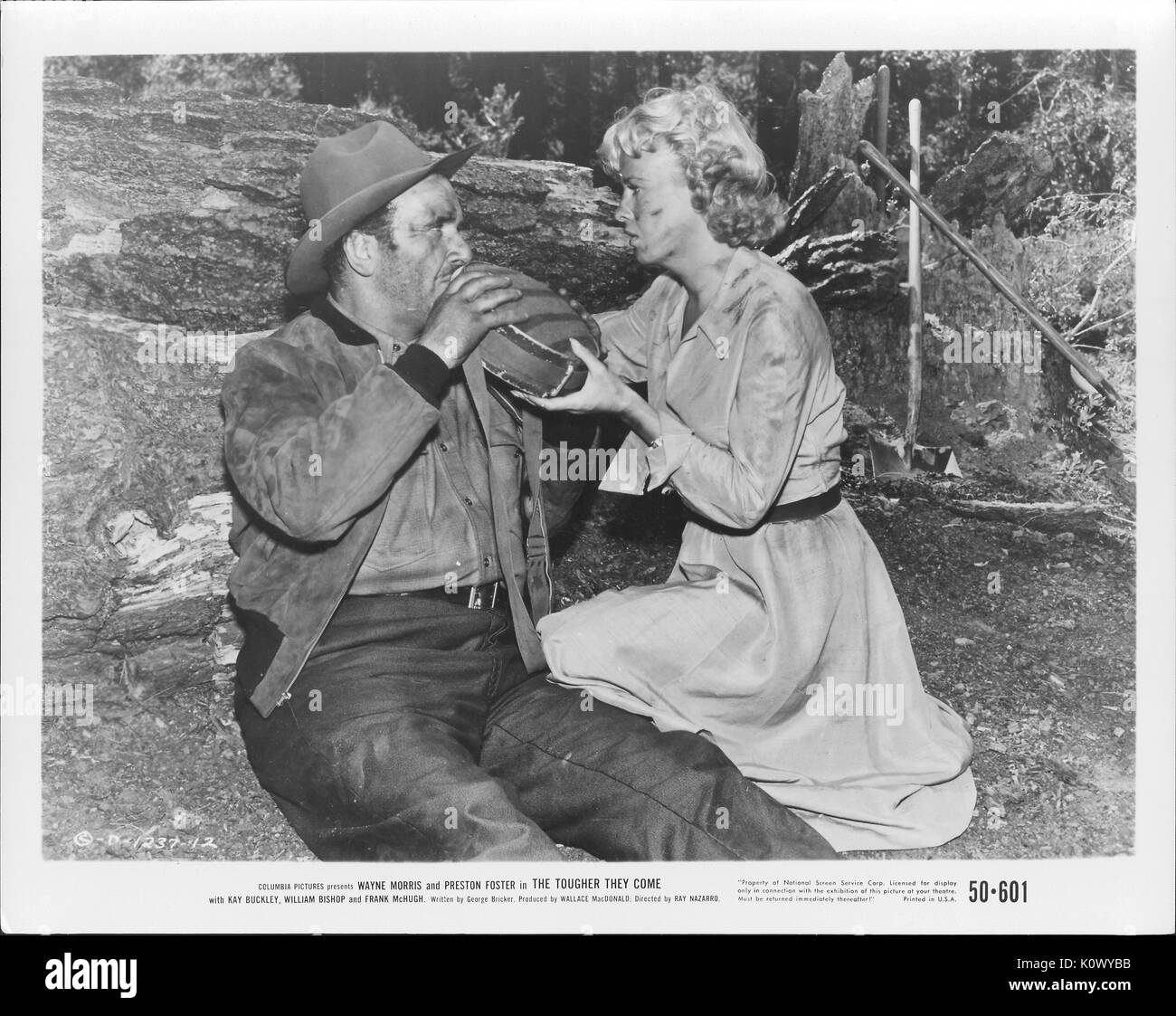 Encore une scène de film 'Le plus difficile qu'ils viennent" (1950) Film de Columbia Pictures, montrant un homme usé sur le sol en position assise tandis qu'une femme avec des traces sur son visage et s'habiller peut contenir jusqu'une outre d'eau à boire pour lui, 1950. Banque D'Images