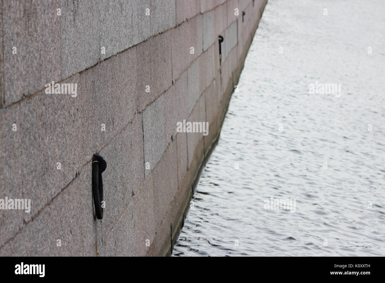 Un canal avec de l'eau pour l'état de navigabilité des navires faisant escale. Historique des anciens murs en pierre avec des bagues métalliques pour l'amarrage Banque D'Images