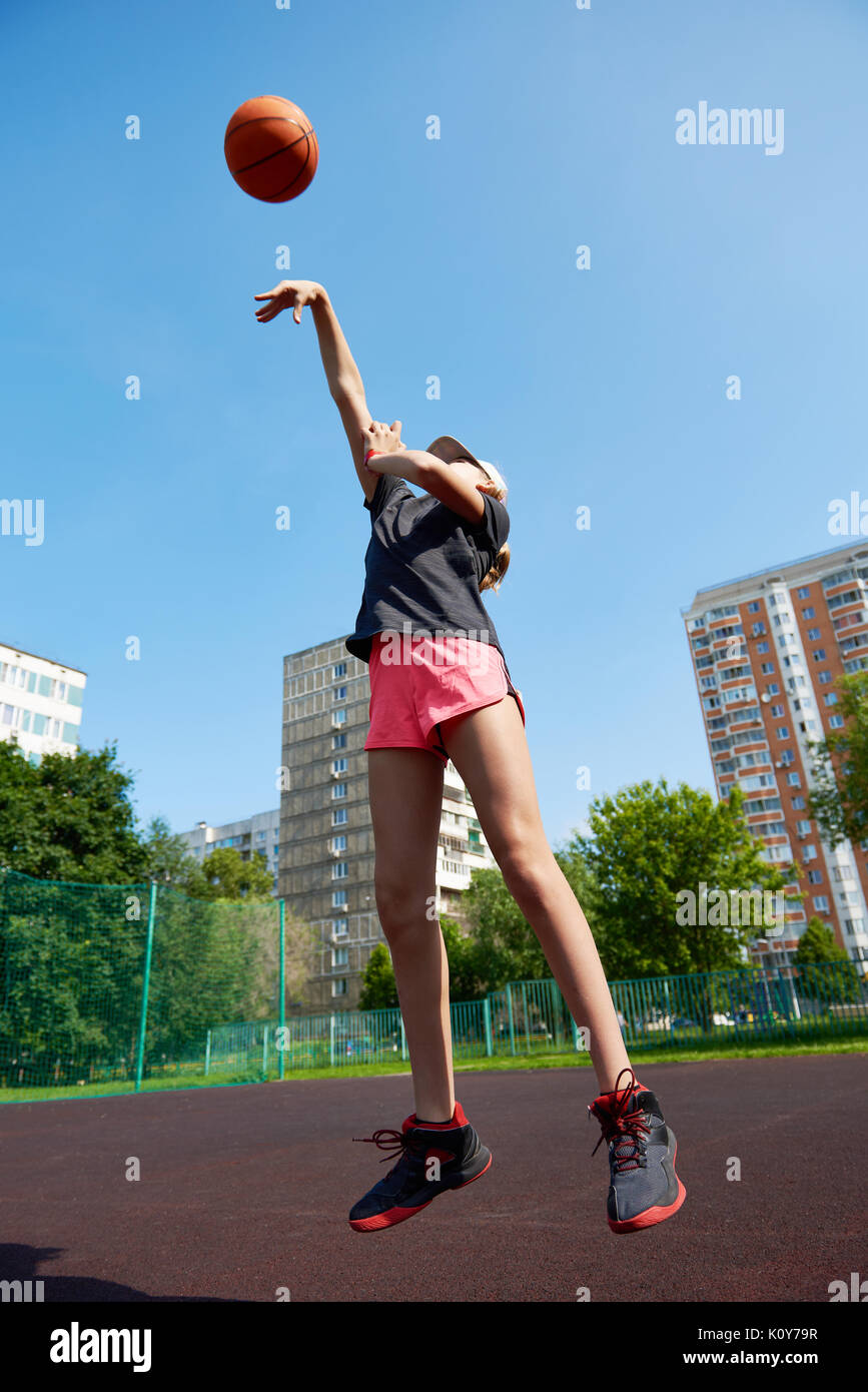 Joueur de basket-ball fille lance la balle vers le haut Banque D'Images