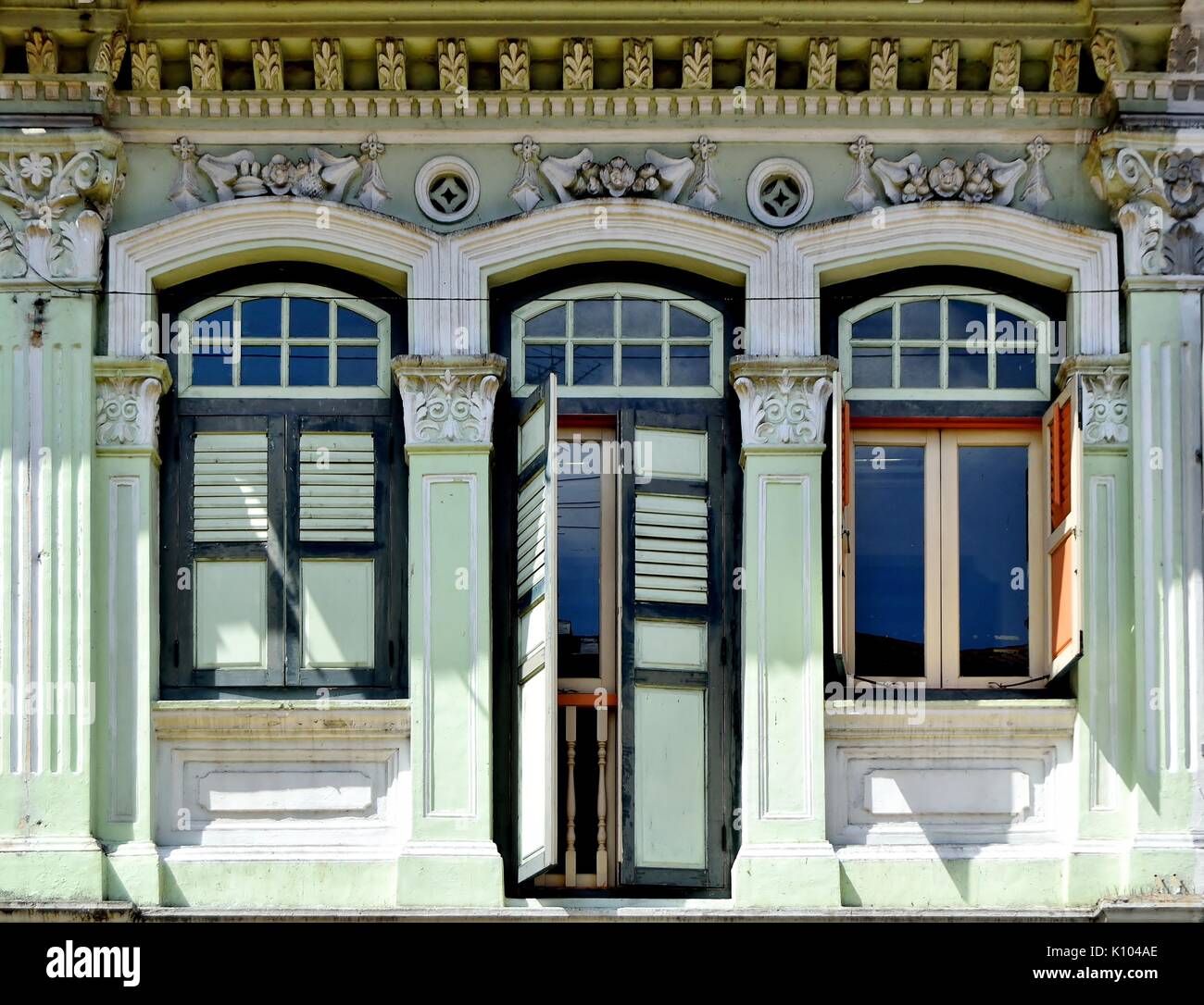 Boutique traditionnel en bois vert extérieur de maison avec les majorquines, fenêtres cintrées et sculptures ornées dans le Little India de Singapour Banque D'Images