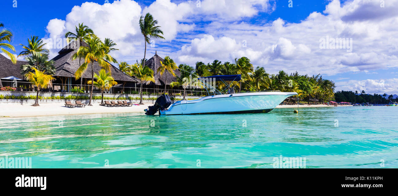 Belle plage de l'ile Maurice,voir avec bateau de vitesse et de palmier. Banque D'Images