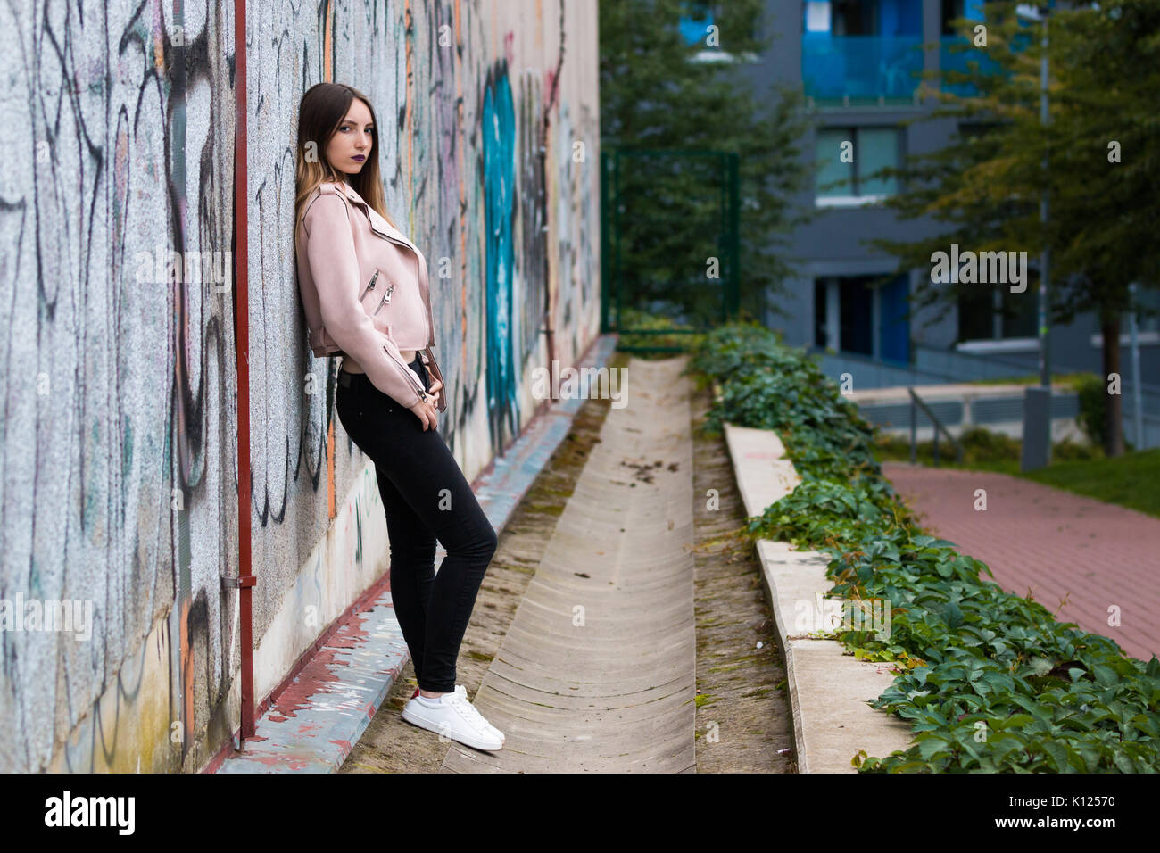 Portrait de jeune fille à la mode informel sur le graffiti wall background Banque D'Images