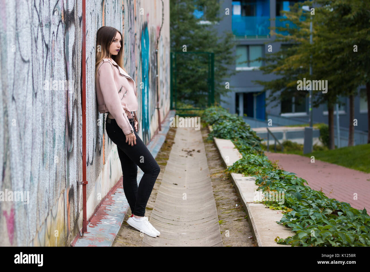 Portrait de jeune fille à la mode informel sur le graffiti wall background Banque D'Images