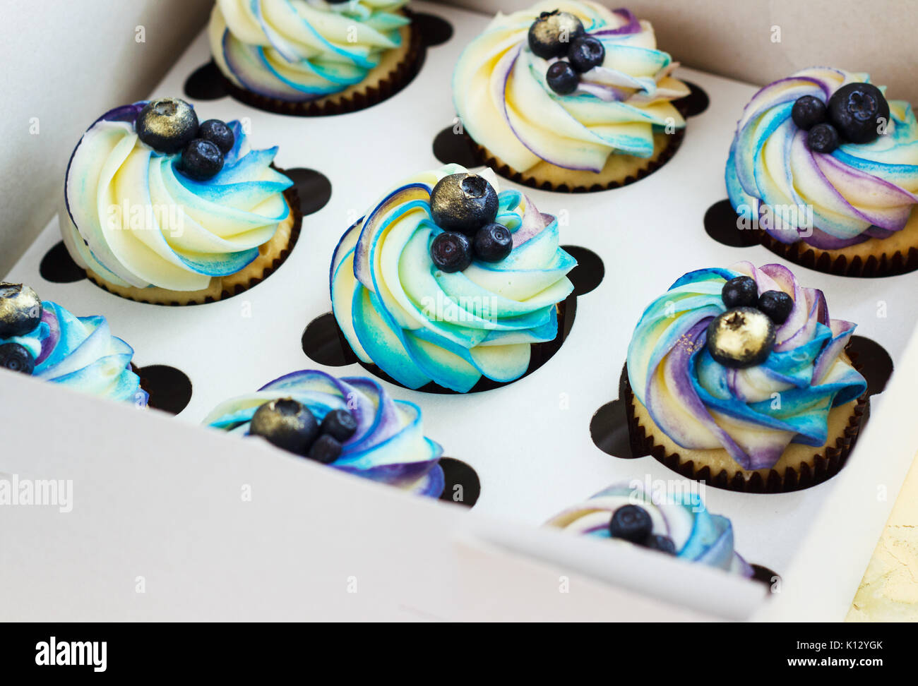 Cupcake doux avec de la crème et les baies dans la boîte. Banque D'Images