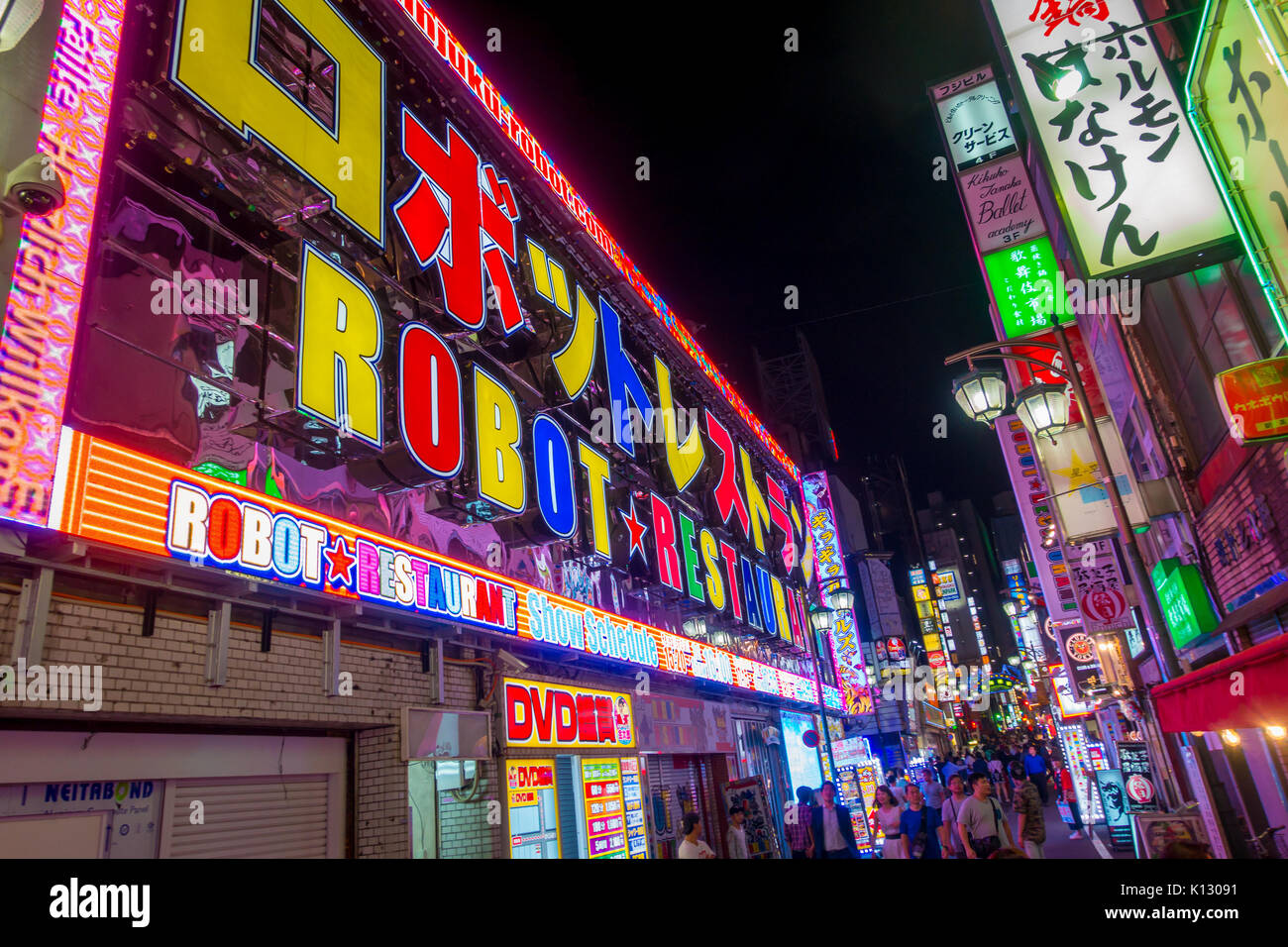 TOKYO, JAPON - 28 juin 2017 : des personnes non identifiées, marcher en dehors d'un robot restaurant situé à feux rouges Kabukicho district, entourant de grands bâtiments et des publicités, situé à Tokyo Banque D'Images