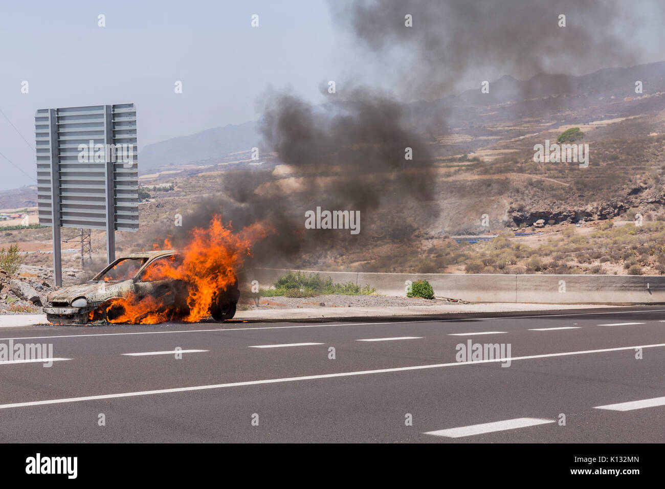 Opel Corsa voiture en feu sur le bord de la route Banque D'Images