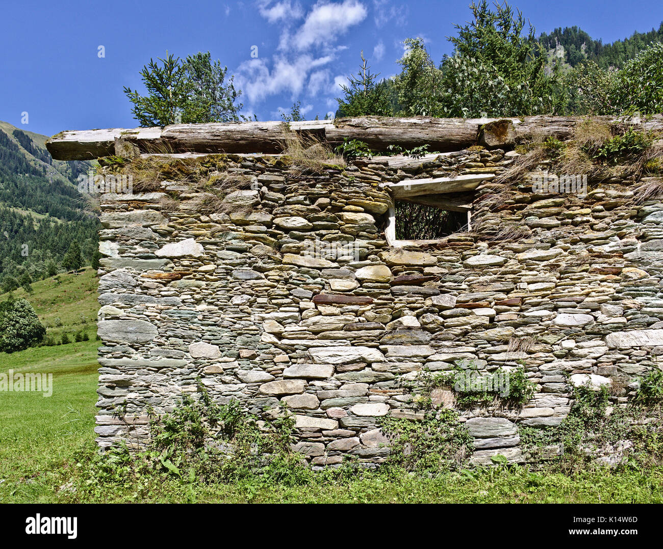 Grange à l'abandon sur le terrain avec des murs en pierre et en face de la fenêtre d'un ciel bleu, dans les Alpes autrichiennes Banque D'Images