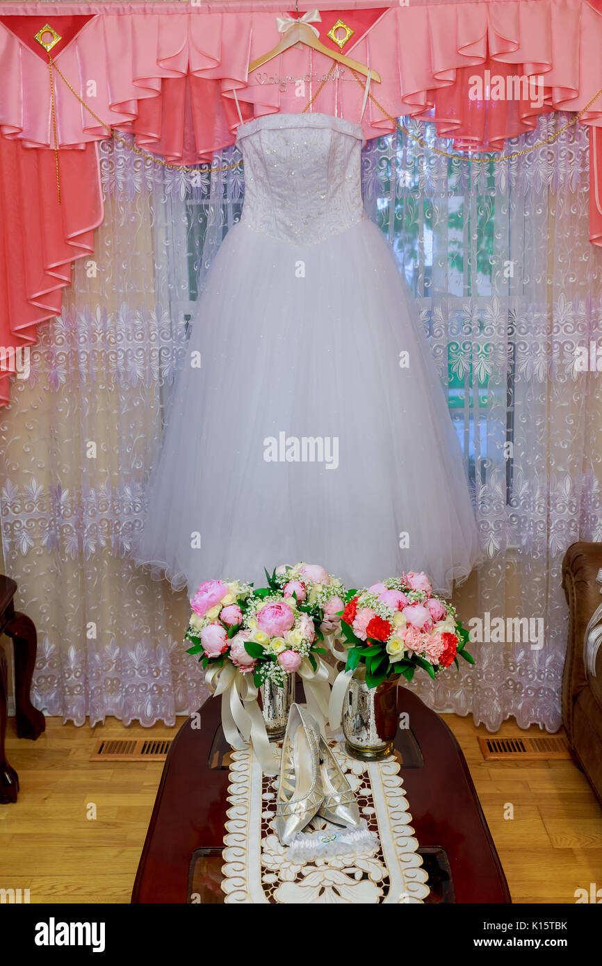 La robe de mariage parfaite avec une jupe ample sur un cintre dans la chambre Banque D'Images