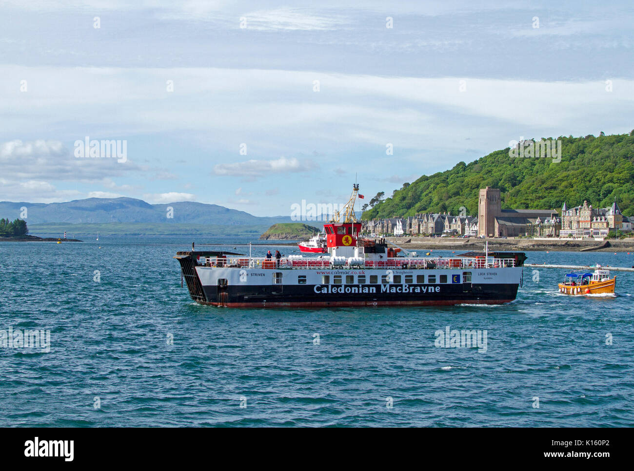 Grand noir et blanc et des véhicules de passagers, Caledonian MacBrayne, port d'Oban en Écosse, avec des bâtiments de la ville en arrière-plan Banque D'Images