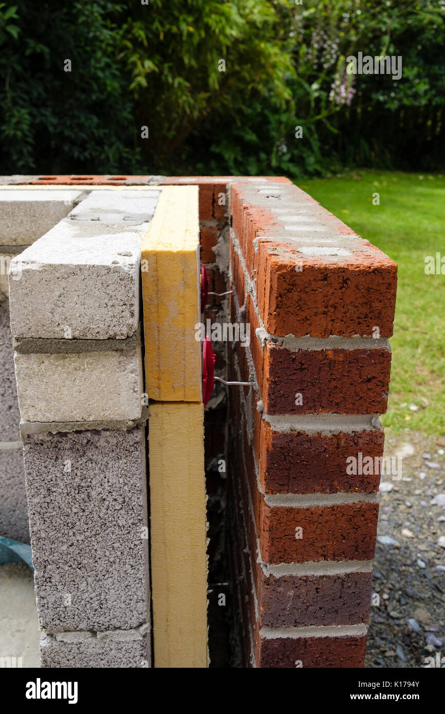 L'isolation des murs creux avec des entretoises entre les briques et parpaings sur un nouveau conservatoire mur nain externe. Royaume-uni, Angleterre Banque D'Images
