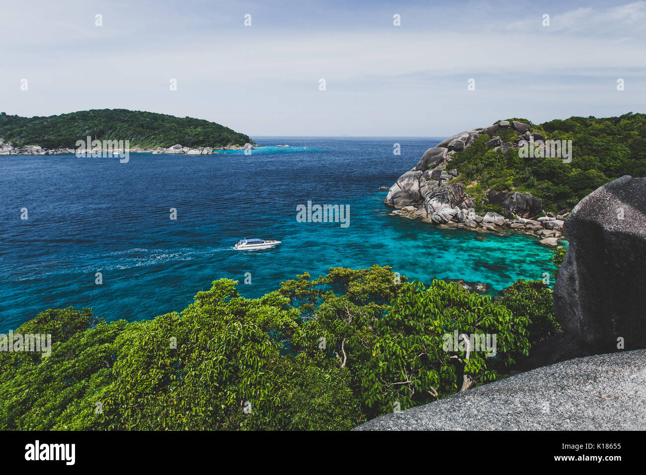Bateau touristique près de la rive de l'île avec de l'eau clair transparent turquoise. Vue idyllique de Similan Banque D'Images