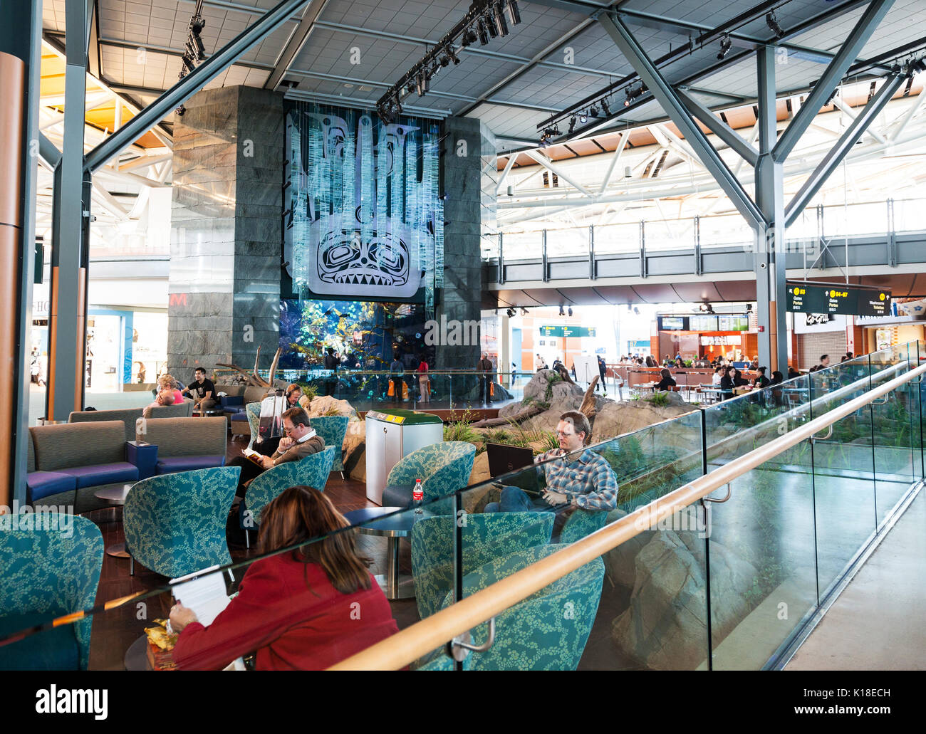 Les passagers à l'Aéroport International de Vancouver (YVR) regarder des poissons dans un aquarium à l'aéroport de Vancouver, British Columbia, Canada Banque D'Images