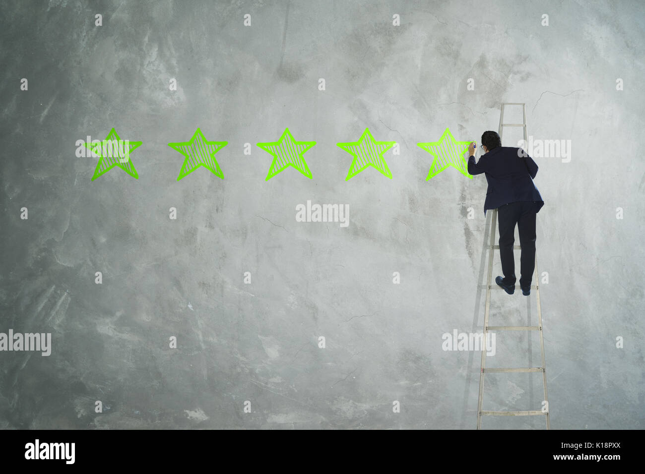 Les hommes de cinq étoiles de dessin sur mur gris . Banque D'Images