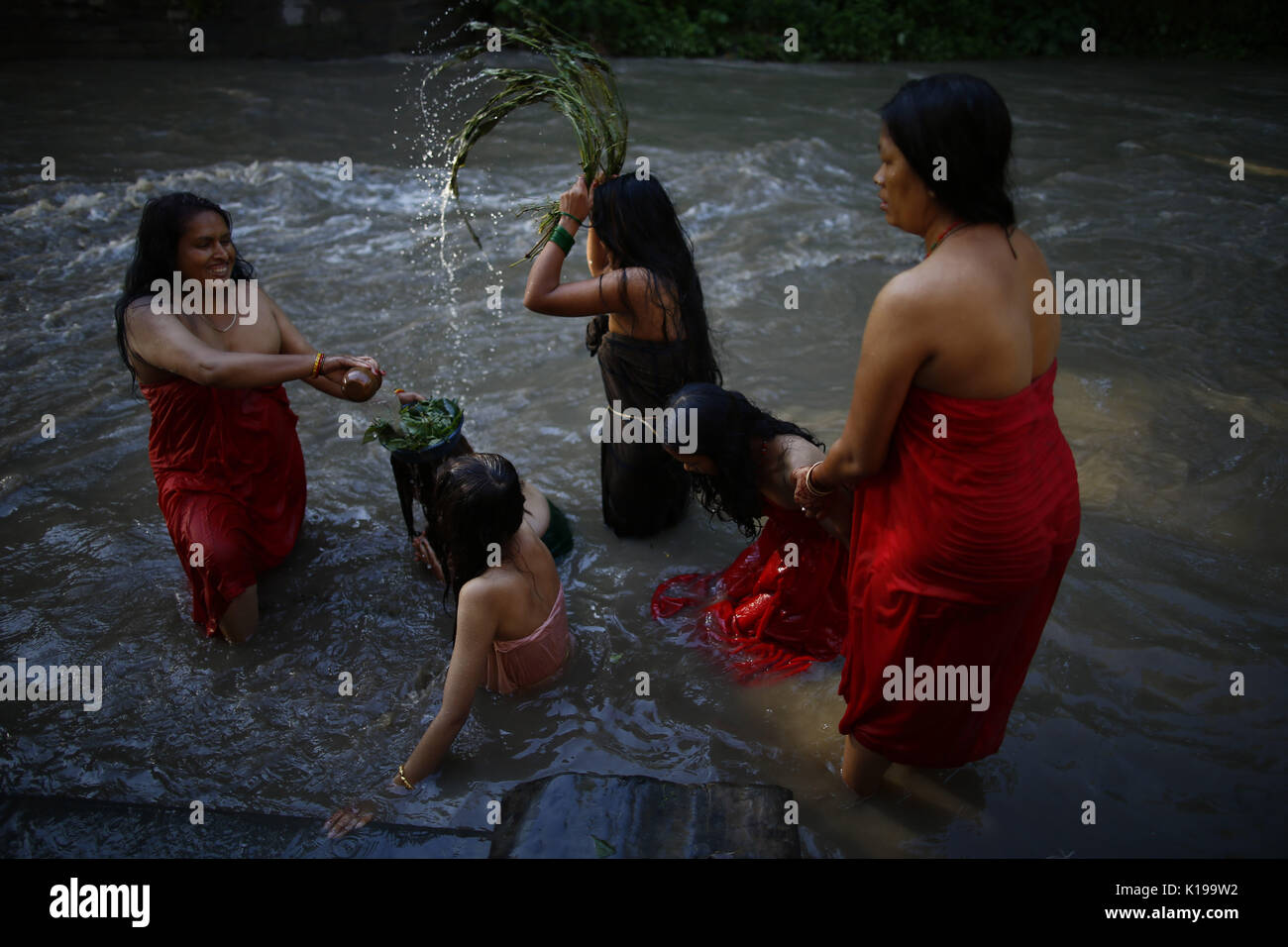 26 août 2017 - Katmandou, Népal Népalais - femmes Hindu effectuer un bain rituel au cours de Rishi Panchami festival sur les rives du fleuve Bagmati à Katmandou, Népal le Samedi, 26 août, 2017. Rishi Panchami est observé pour marquer la fin de trois jours de festival Teej lorsque les femmes adorent Sapta Rishi (Sept Saints) le dernier jour en nettoyant leurs corps avec 365 tiges d'Apamarga, une plante médicale, prenez bath avec de la bouse de vache et de sol prélevés dans des lieux sacrés et des cendres dans la croyance qu'ils soient bénis et pardonné de tous les péchés qu'ils étaient soupçonnés d'avoir commis pendant le cycle menstruel et laver Banque D'Images