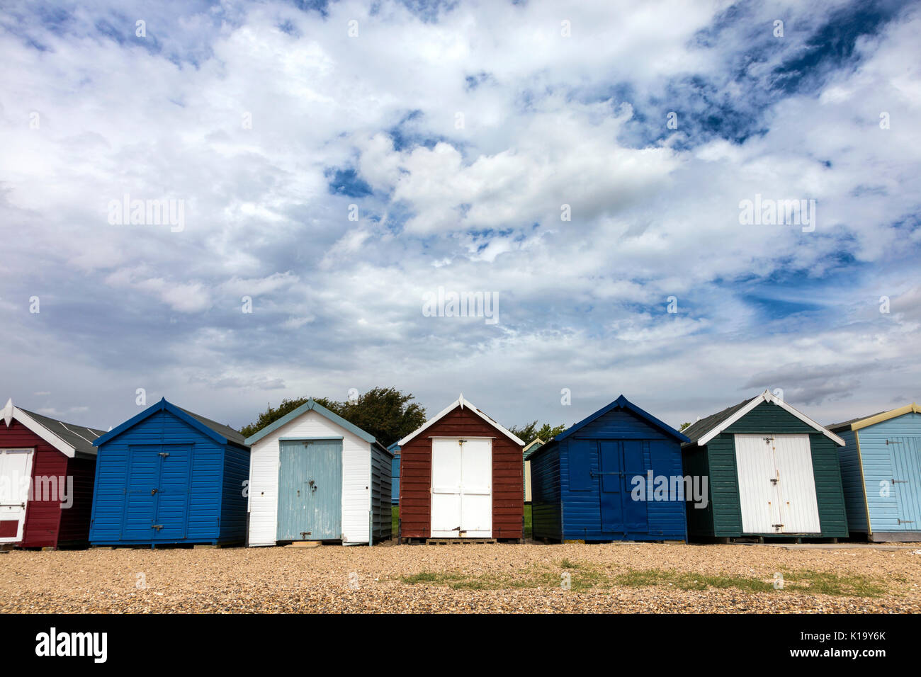 Une rangée de cabines colorées at Mersea Island, Essex, UK Banque D'Images