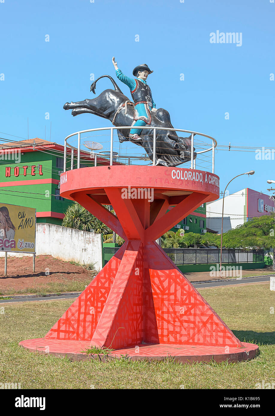 Colorado, Brésil - Juillet 22, 2017 : Statue d'un rodeo cowboy monté sur un taureau rouge sur une structure. Vue sur l'entrée de la ville Colorado - Paran Banque D'Images