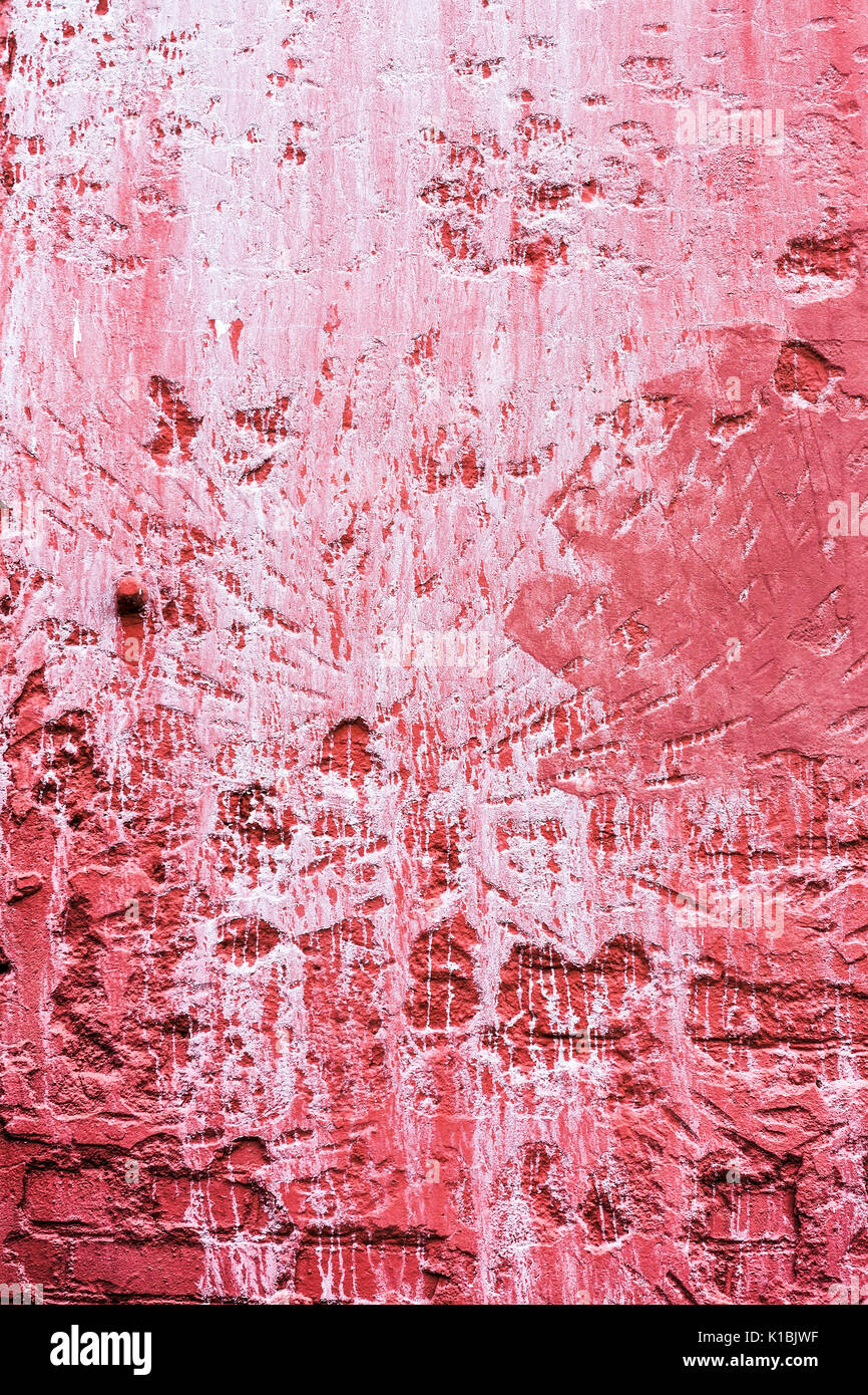 Weathered texture de mur de plâtre rouge avec des gouttes de peinture blanche Banque D'Images