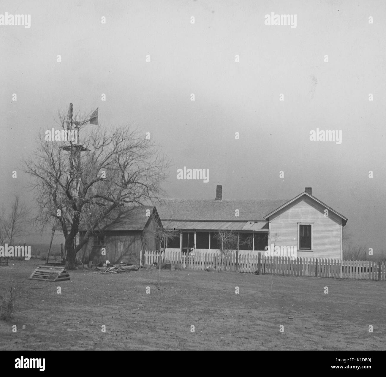 Kansas farm house, dans un champ avec un moulin à vent, au cours de l'ère dustbowl, 1935. à partir de la bibliothèque publique de new york. Banque D'Images