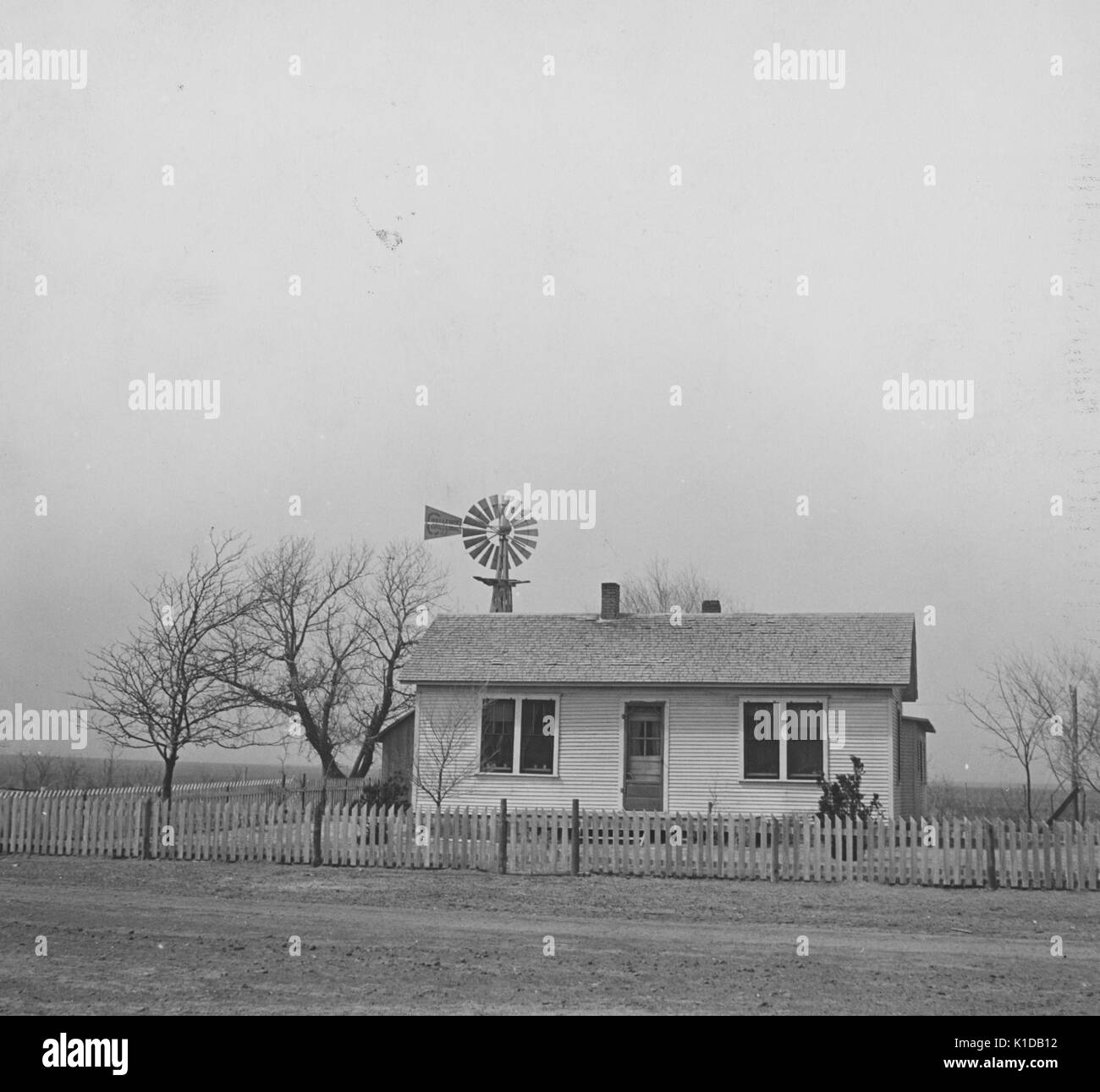 Kansas farm house, dans un champ avec un moulin à vent, au cours de l'ère dustbowl, 1935. à partir de la bibliothèque publique de new york. Banque D'Images