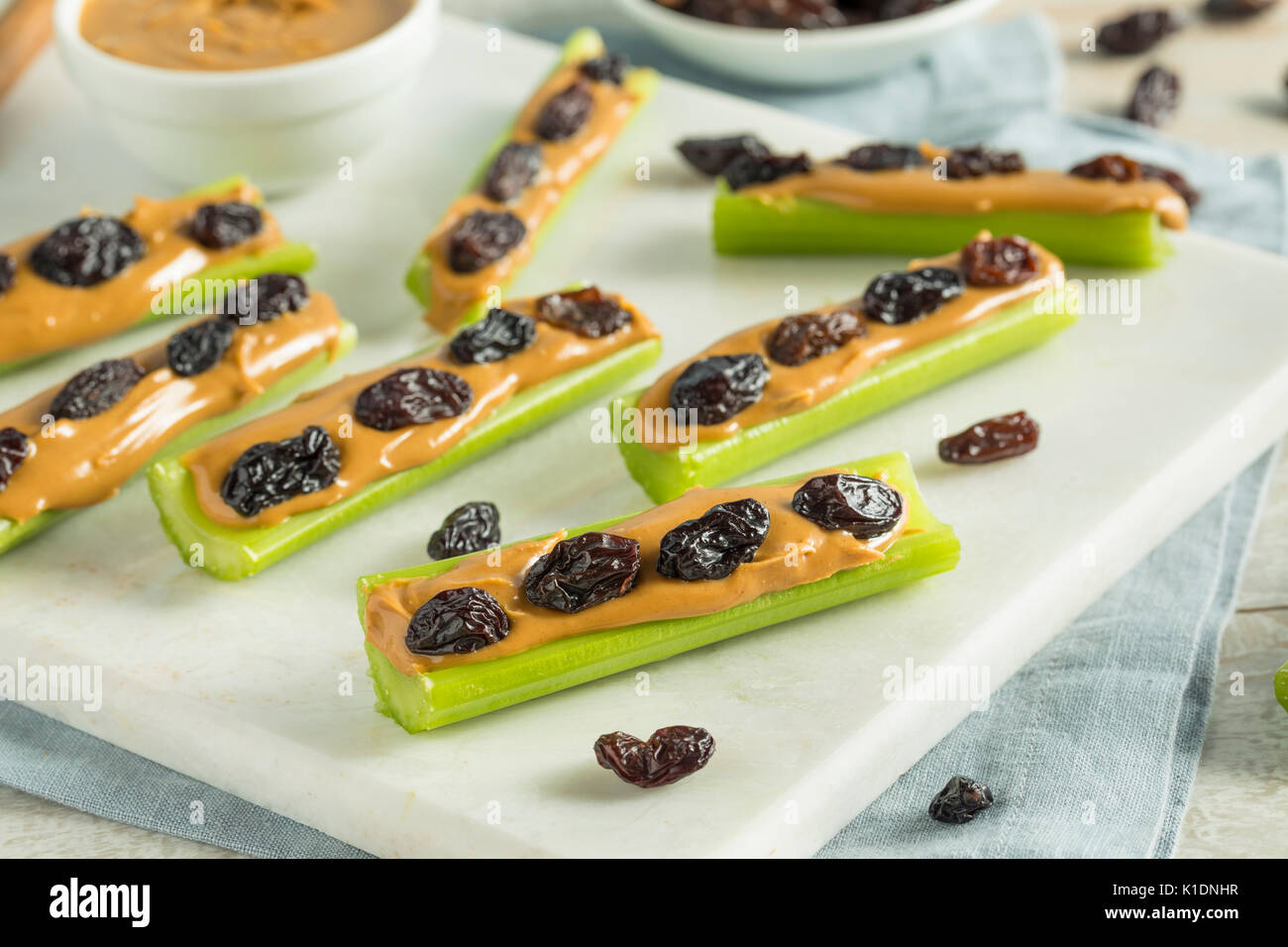 Des fourmis sur un journal Snack avec du beurre d'arachides et raisins Céleri Banque D'Images