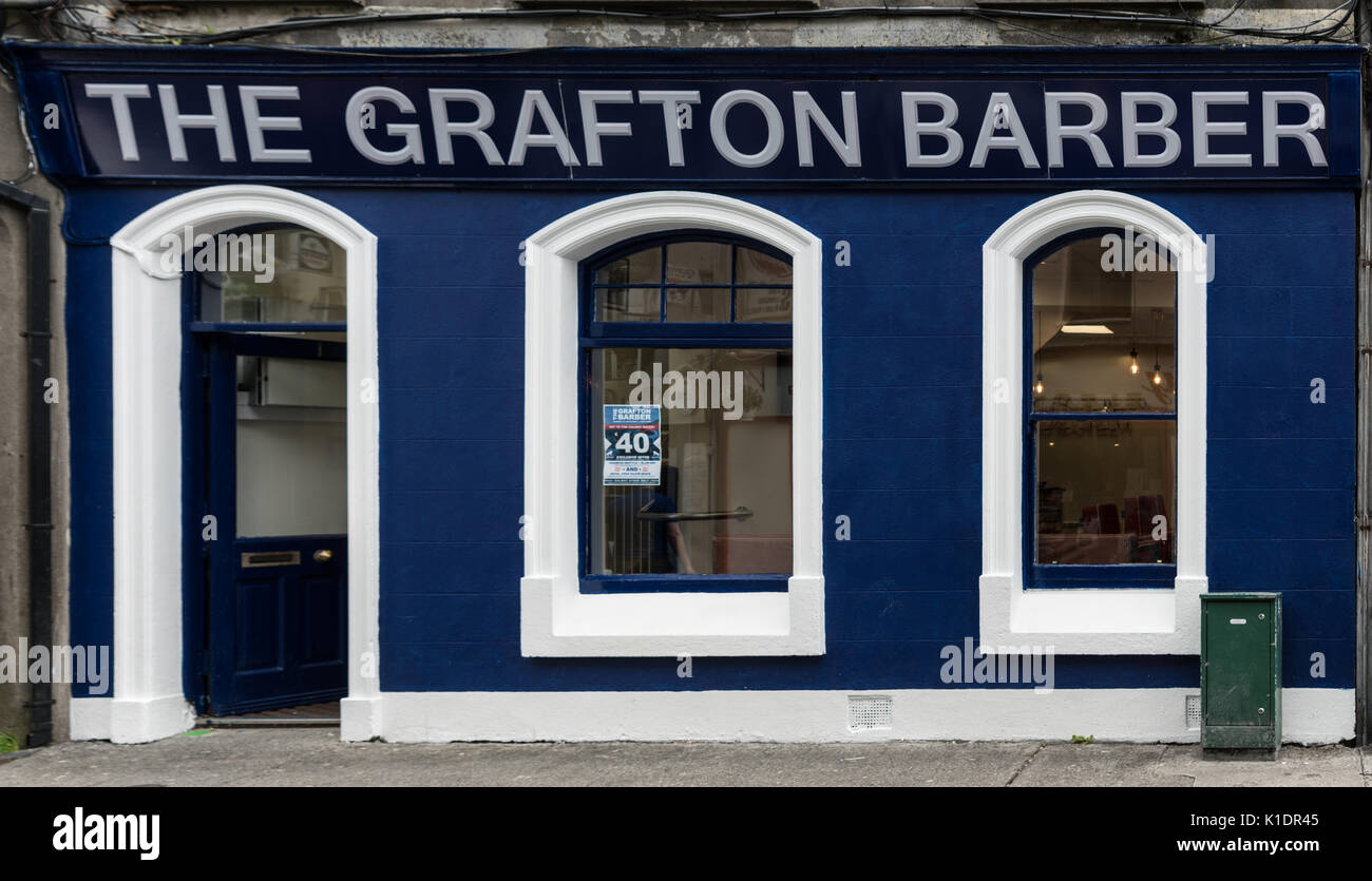 Galway, Irlande - Août 3, 2017 : façade de la petite entreprise de coiffure nommé Grafton dispose de peinture bleu et blanc, ouvrez la porte et petites fenêtres. Street sce Banque D'Images
