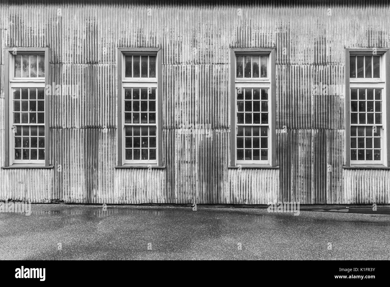 Old rusty metal hangar avec de grandes fenêtres en noir et blanc gros plan Banque D'Images