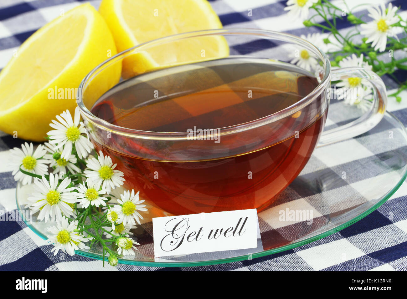 Carte de prompt avec une tasse de thé, de fleurs de camomille et de citron frais Banque D'Images