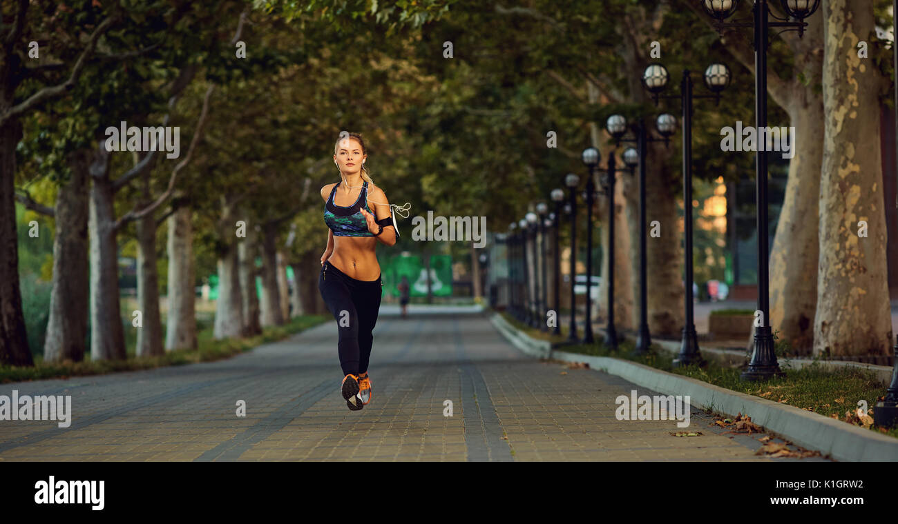 Jeune fille athlétique jogging runner dans le parc en été automne Banque D'Images