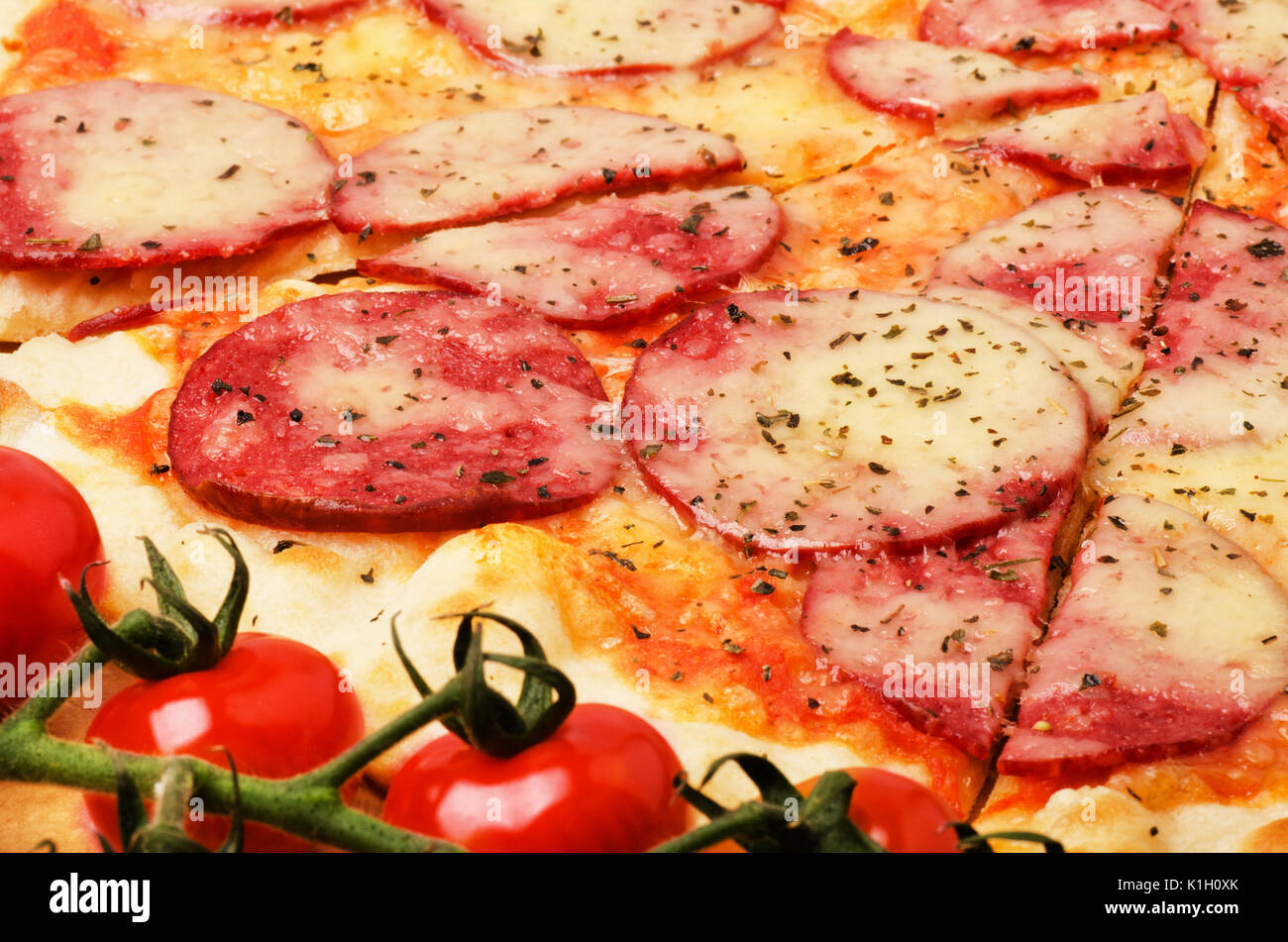 Pizza salami savoureux avec des ingrédients cerises close-up Banque D'Images